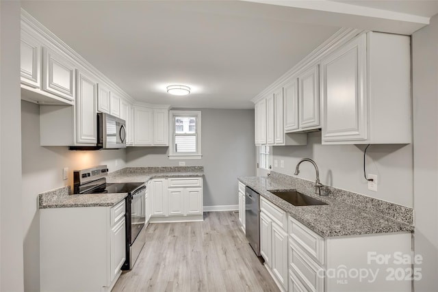 kitchen with light stone countertops, sink, white cabinetry, and appliances with stainless steel finishes