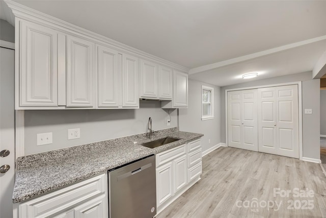 kitchen with stainless steel dishwasher, white cabinets, and sink