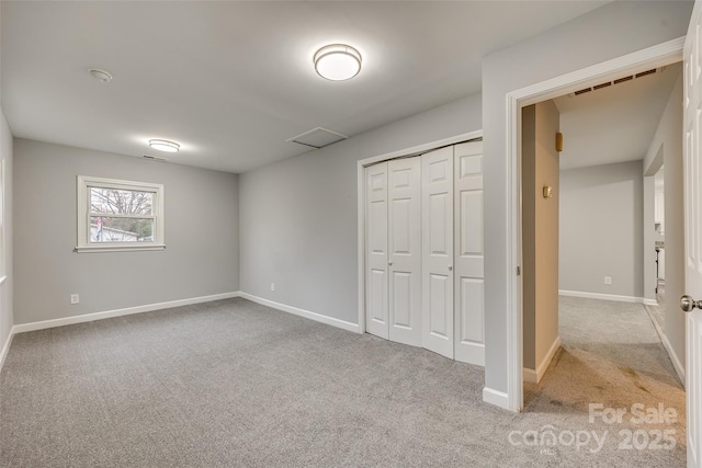 unfurnished bedroom with a closet and light carpet