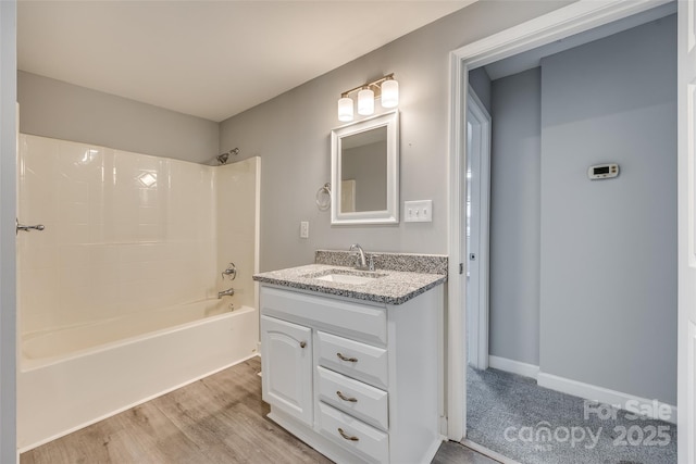 bathroom with vanity, hardwood / wood-style flooring, and washtub / shower combination