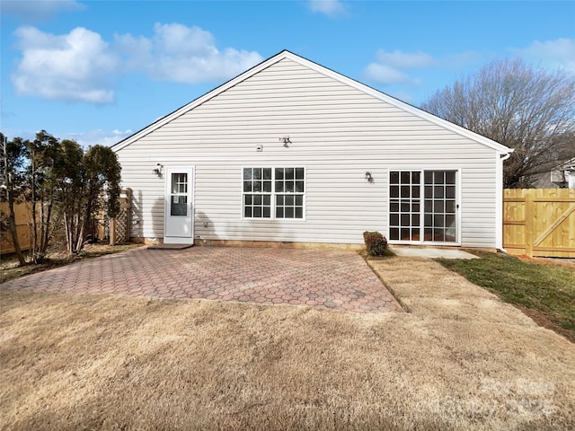 back of house with a patio area and a lawn