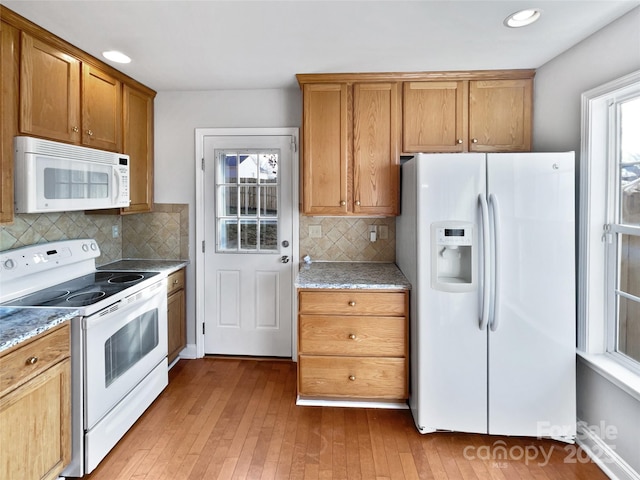 kitchen with light stone counters, white appliances, and decorative backsplash