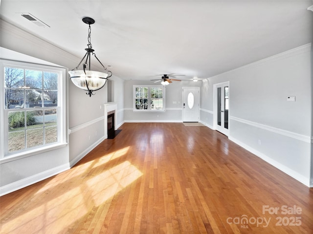 unfurnished living room featuring ceiling fan, ornamental molding, and hardwood / wood-style floors