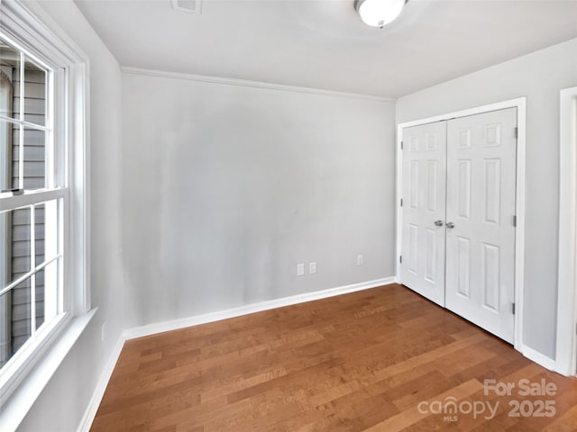 unfurnished bedroom featuring wood-type flooring and a closet