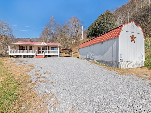 view of front of home with a porch and a carport