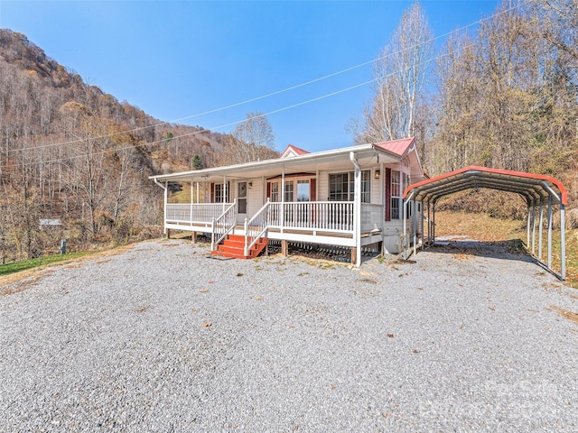 view of front of property with covered porch, a carport, and a mountain view