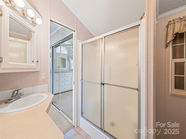 bathroom with sink, a textured ceiling, walk in shower, and crown molding