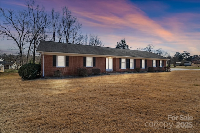 single story home featuring a lawn