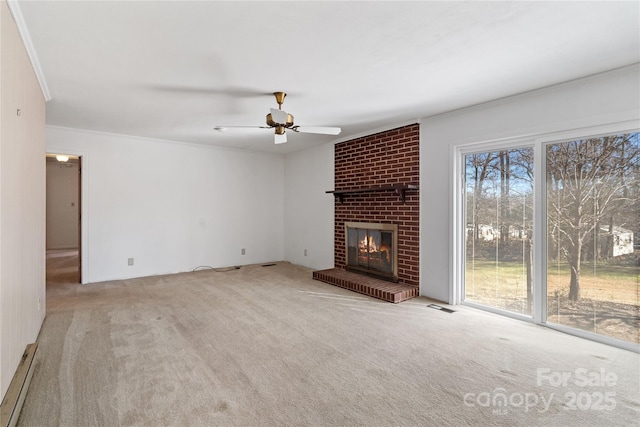 unfurnished living room with a brick fireplace, plenty of natural light, light colored carpet, and ceiling fan