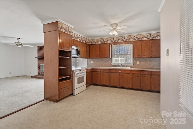 kitchen featuring a brick fireplace, white electric range, sink, ornamental molding, and light carpet