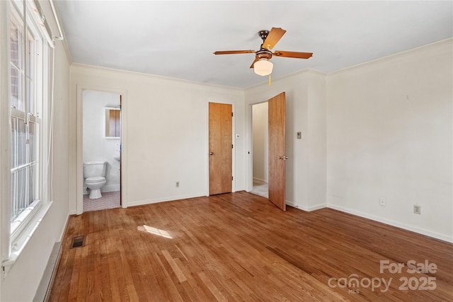 unfurnished bedroom with ceiling fan, ensuite bath, crown molding, and hardwood / wood-style flooring