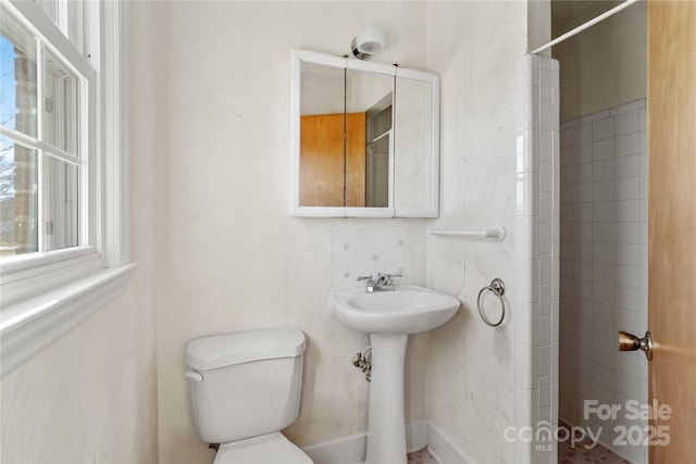 bathroom featuring toilet, sink, and walk in shower