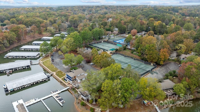 birds eye view of property featuring a forest view and a water view