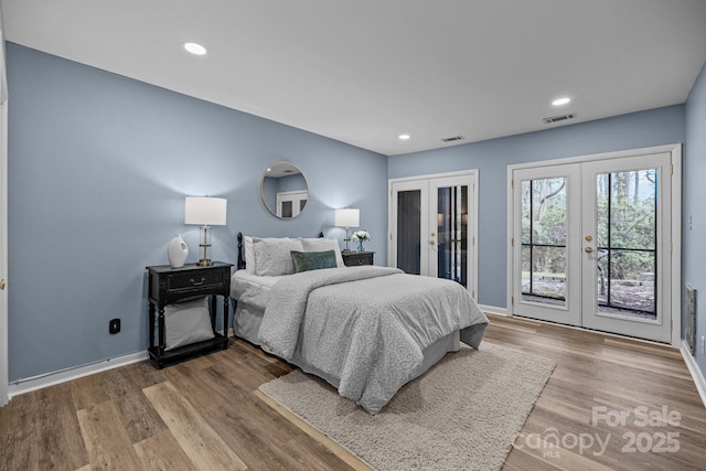 bedroom with access to exterior, french doors, visible vents, and wood finished floors