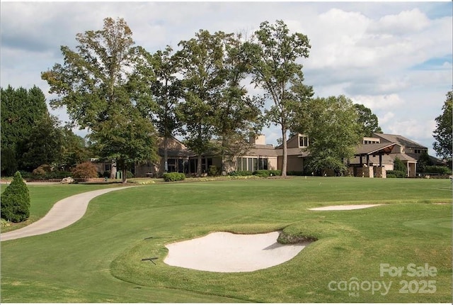 surrounding community with golf course view and a lawn