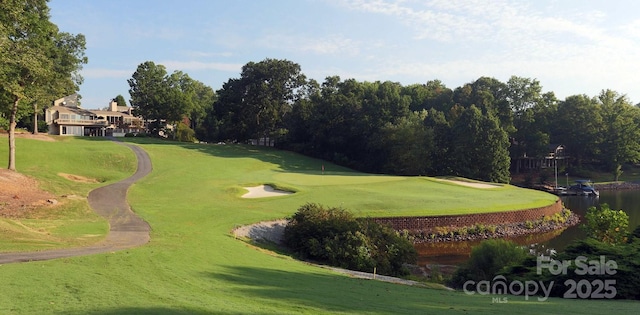 surrounding community featuring golf course view, a water view, and a lawn