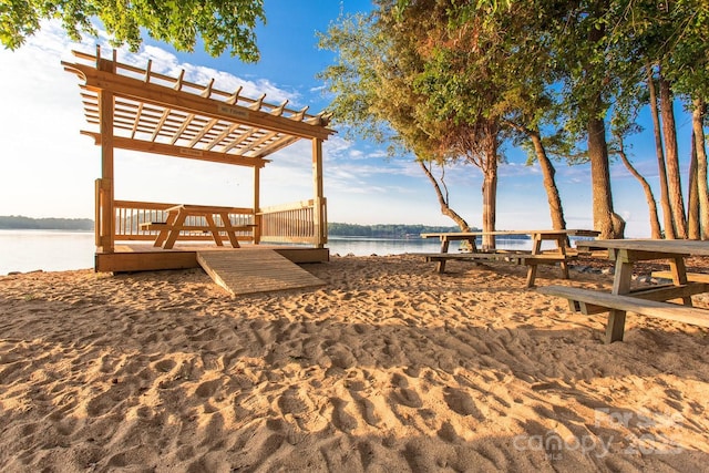 exterior space with a water view and a pergola