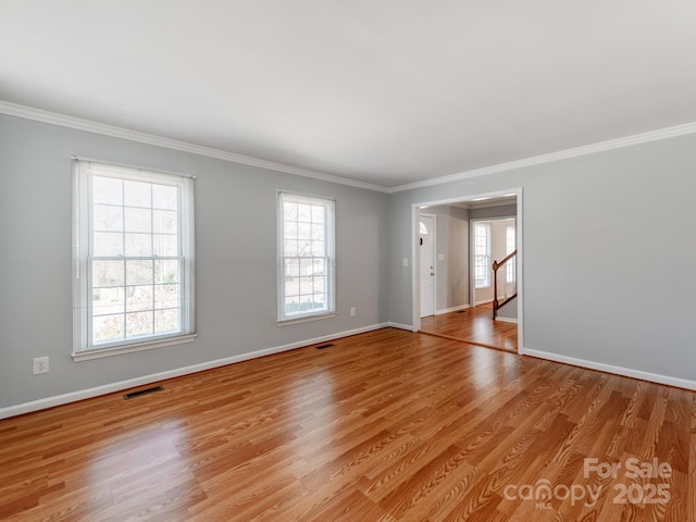 unfurnished room with light wood-type flooring, a wealth of natural light, and ornamental molding