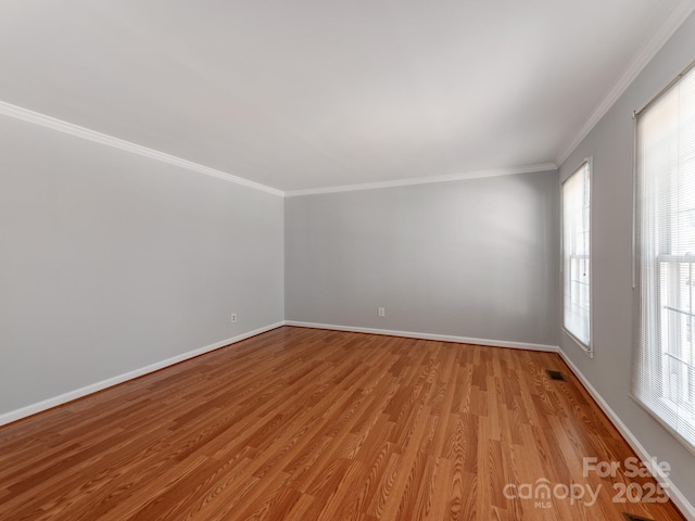 spare room with crown molding and light hardwood / wood-style floors