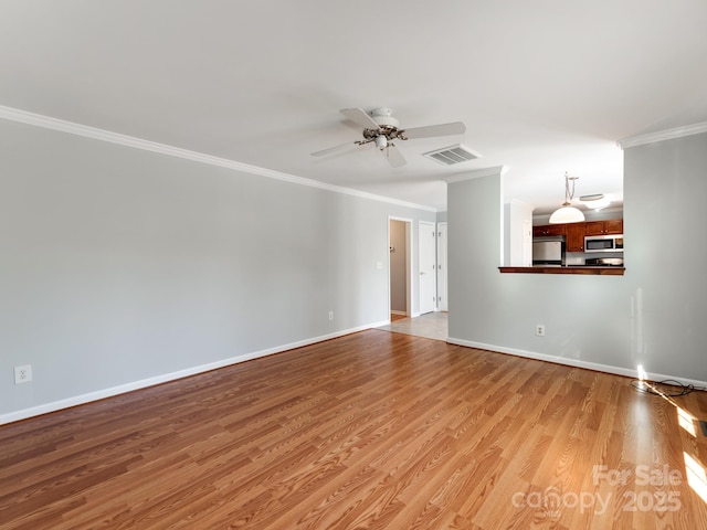 unfurnished living room with ceiling fan, ornamental molding, and light wood-type flooring