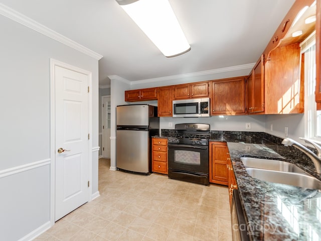 kitchen featuring appliances with stainless steel finishes, dark stone countertops, ornamental molding, and sink