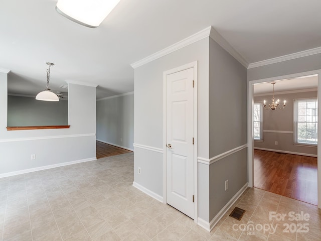 tiled spare room featuring ornamental molding and a notable chandelier