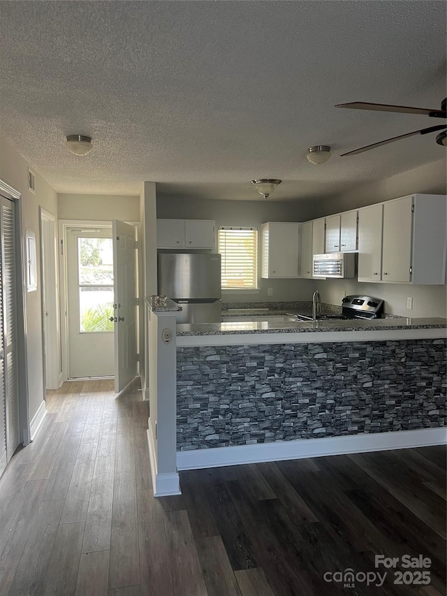 kitchen featuring white cabinetry, stainless steel appliances, hardwood / wood-style flooring, and plenty of natural light