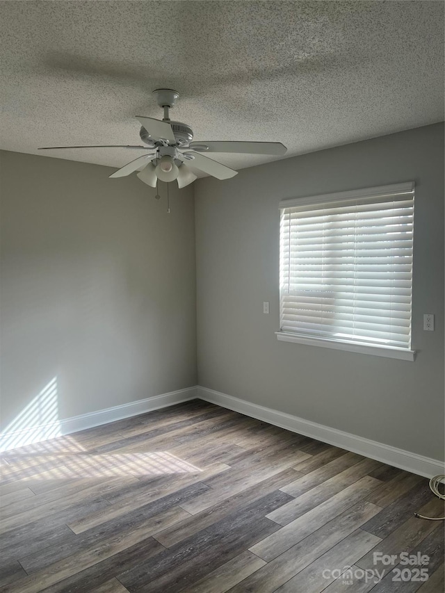 empty room with ceiling fan, a textured ceiling, and dark hardwood / wood-style flooring