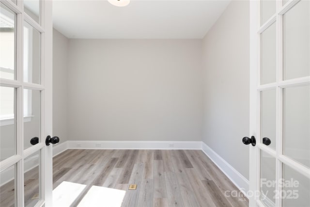 laundry room featuring french doors and light hardwood / wood-style flooring