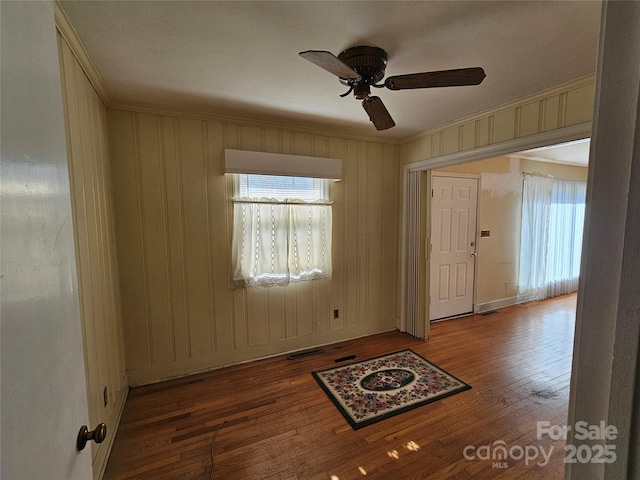 unfurnished room with ceiling fan, a healthy amount of sunlight, hardwood / wood-style floors, and crown molding