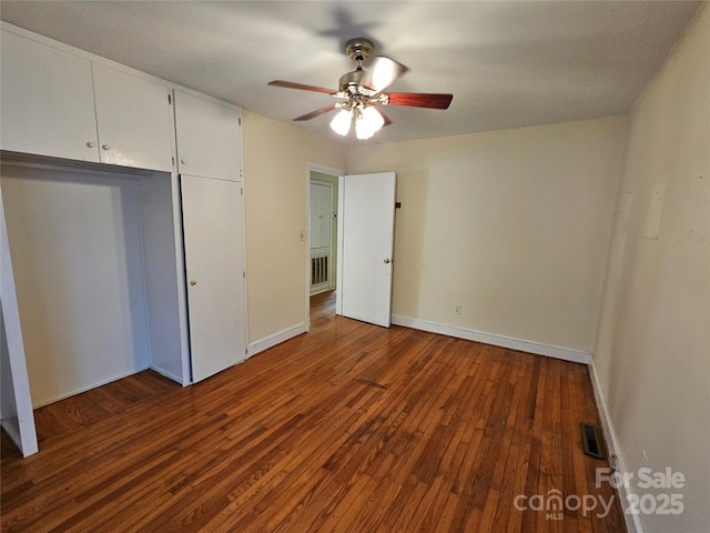 unfurnished bedroom featuring dark wood-type flooring and ceiling fan