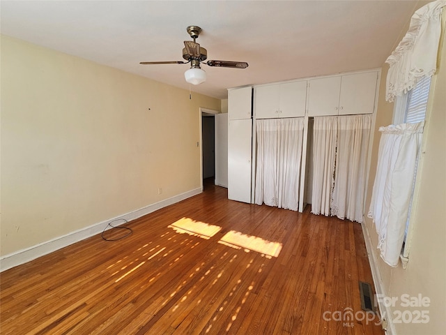 unfurnished bedroom with ceiling fan, hardwood / wood-style flooring, and a closet