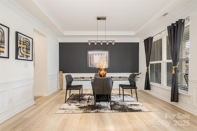 dining area featuring ornamental molding and light wood-type flooring