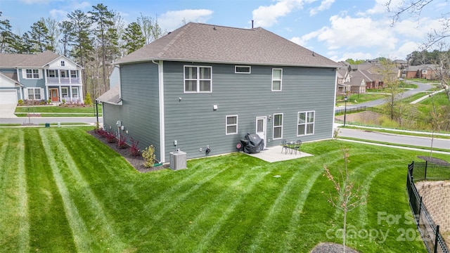 rear view of property with a lawn, central AC, and a patio area