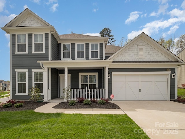 view of front facade featuring a garage, a front lawn, and a porch