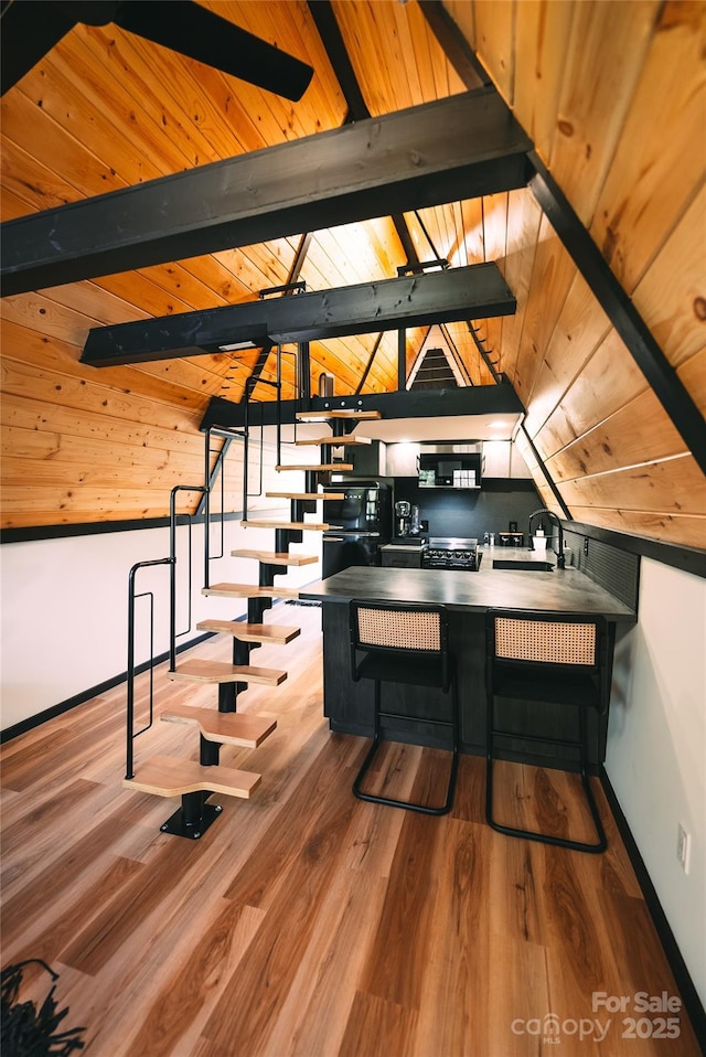 interior space with sink, wood-type flooring, wooden ceiling, and lofted ceiling with beams