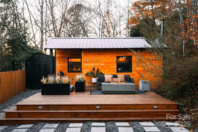 wooden terrace featuring an outdoor living space with a fire pit