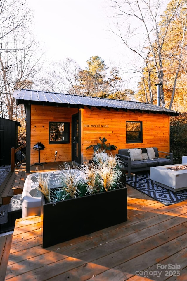 wooden deck featuring an outdoor living space with a fire pit