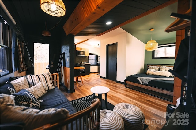 bedroom featuring hardwood / wood-style floors and vaulted ceiling with beams