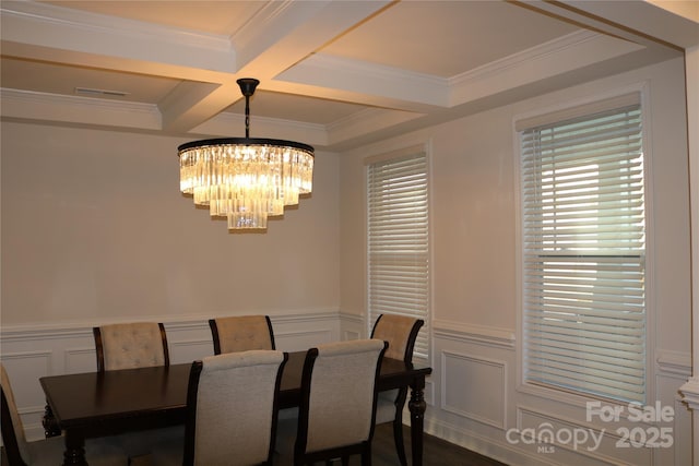 dining space featuring crown molding, an inviting chandelier, beamed ceiling, and coffered ceiling