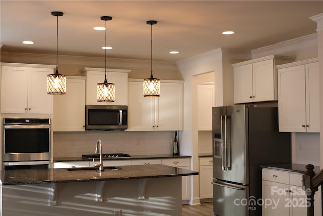 kitchen featuring white cabinetry, pendant lighting, appliances with stainless steel finishes, and dark stone counters