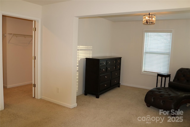 living area with light carpet and a chandelier