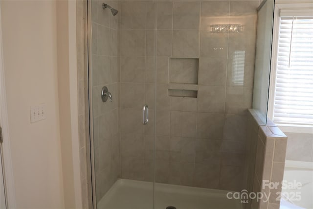 bathroom featuring plus walk in shower and plenty of natural light