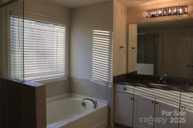 bathroom featuring vanity and shower with separate bathtub