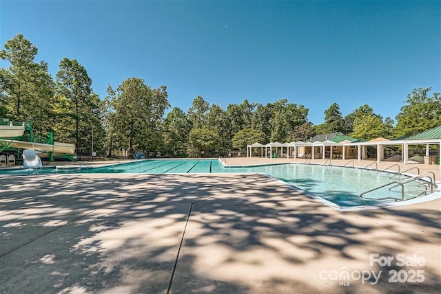 view of swimming pool featuring a patio area and a water slide