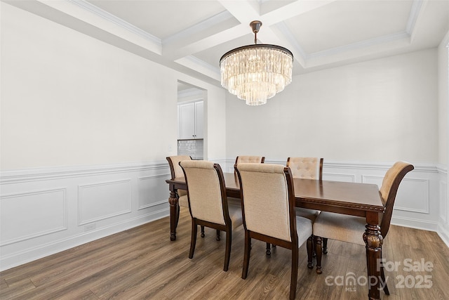 dining room with crown molding, hardwood / wood-style floors, coffered ceiling, a notable chandelier, and beamed ceiling