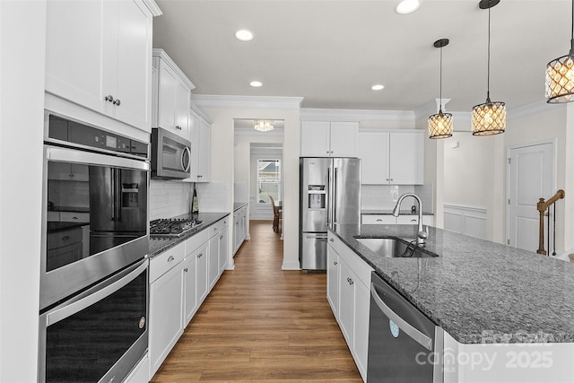 kitchen with a kitchen island with sink, sink, stainless steel appliances, and white cabinets