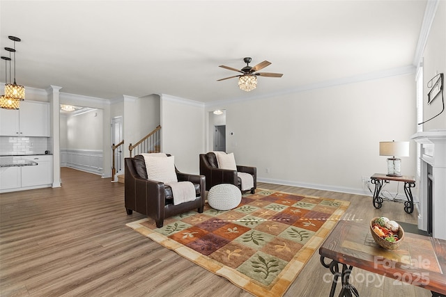 living room with crown molding, ceiling fan, and hardwood / wood-style floors