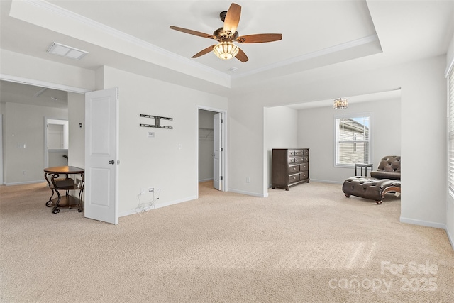 sitting room with ornamental molding, a tray ceiling, and light carpet