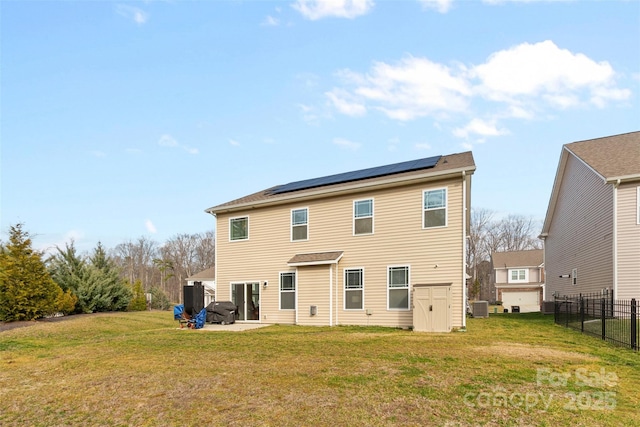 rear view of property with cooling unit, a yard, a patio, and solar panels